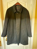 Front view of dark charcoal mac coat on hanger showing overall style