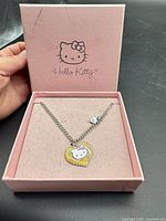Necklace displayed inside pink Hello Kitty box