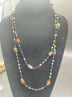 Necklace displayed draped on bust showing full double-loop length and bead colours