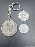 Overview of three religious medals: large keychain medallion and two smaller pendants