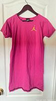 Full view of pink Nike Air Jordan dress on hanger
