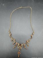 Full view of necklace laid flat showing overall design and chain