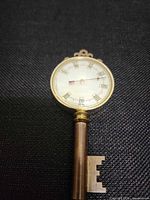 Front view of key-shaped thermometer showing dial and key bit