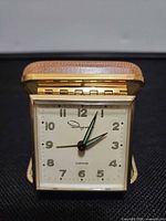 Front view of clock showing dial, casing and foldable design