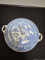 top view of covered serving dish displaying Willow pattern and twin handles