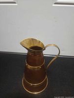 Full view of copper pitcher showing tapered form, handle and bands