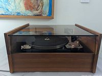 Turntable inside wood plinth with tinted dust cover closed