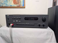 Front view of NAD T760 receiver showing display, controls, and connected RCA cables