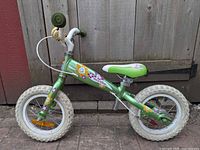 Right side view of green Opus BeeBike balance bike showing frame, wheels, handlebar and graphics