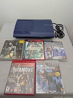 Console, power cable and five game cases displayed on table