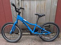 Left side view of blue Trek Precaliber 20" kids bike showing whole frame, wheels, components