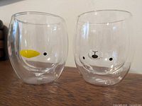 Front view of both clear animal face mugs