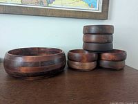Entire set showing one large bowl beside stack of seven small bowls