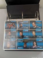 Binder open showing nine Star Trek TNG trading cards in plastic page