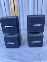 Front view of both stacked Bose cube speakers showing logos