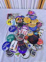 Full group of assorted promotional pinback buttons on table