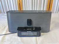 Front view showing speaker grille, clock display, and 30-pin dock