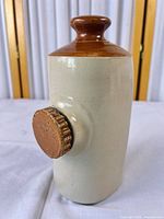 Full view of stoneware bed warmer showing beige body and brown neck