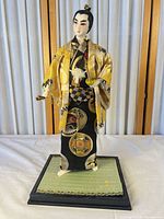 Full view of samurai doll on base