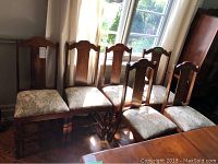 Six chairs lined up in front of window showing entire set