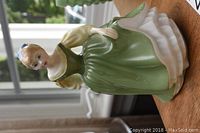Front angled view of Royal Doulton figurine showing details of dress and face.
