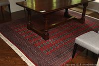 Full view of red Bukhara wool rug under dining table