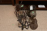 Photo showing two metal pumpkin lanterns, one metal pear decor, and bird statue grouped together on carpet.