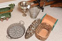 Photo showing hand-painted small green wooden bookshelf, various metal trays including scrolled wire tray, leaf design tray, wire mesh trash basket, silver champagne chiller, and wicker baskets.