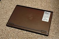 Closed Dell Vostro V13 laptop with bronze lid and Dell logo, showing MaxSold sticker.