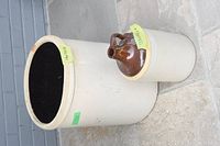 Photo shows large beige vintage crock pot with open top, sitting on tile surface, with sticker labels visible.
