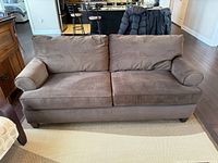 Front view of brown corduroy sofa showing cushions, arms and feet