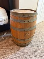 Full view of wooden barrel side table showing top and metal bands