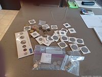 Overview of coins on countertop, year set visible, coins in holders and bags