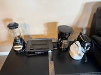 All five small appliances lined up: blender, grill, coffee maker, toaster, cooker