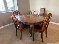table, four chairs, leaf leaning against wall