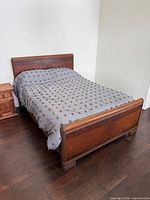 Full view of assembled wood double bed with mattress and bedding