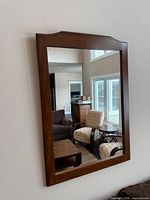 Front view of wood framed rectangular wall mirror mounted on wall