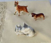 Three porcelain dog figurines grouped on cloth