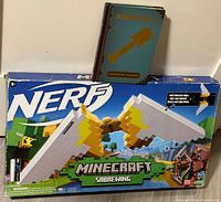 Front of boxed Nerf Minecraft Sabrewing blaster with book on top