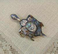 Front view of turtle brooch showcasing abalone inlay and silver construction