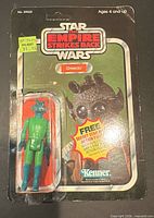 Front view of carded Greedo figure showing logo, bubble and price sticker