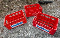 Three crates on gravel showing logos and overall wear