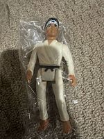 Figure in clear bag showing full front view with gi, belt and headband