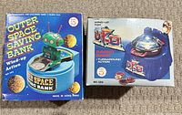 Boxes for both Ever Rite wind-up coin banks showing product images and model numbers 565 and 569