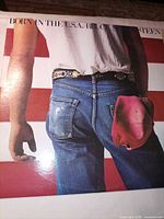 Front album cover showing flag backdrop and jeans pocket
