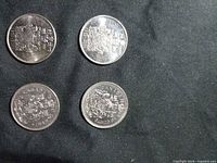 Four Canada 50-cent coins on black background