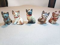 Group shot of five resin cat figurines with hanging cords