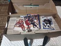 Box filled with organized stacks of hockey cards; three cards on top feature Eric Lindros, Brett Hull, Felix Potvin