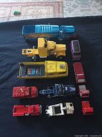 Group shot of all 12 die-cast vehicles on black cloth