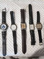 All five watches laid flat showing dials and straps